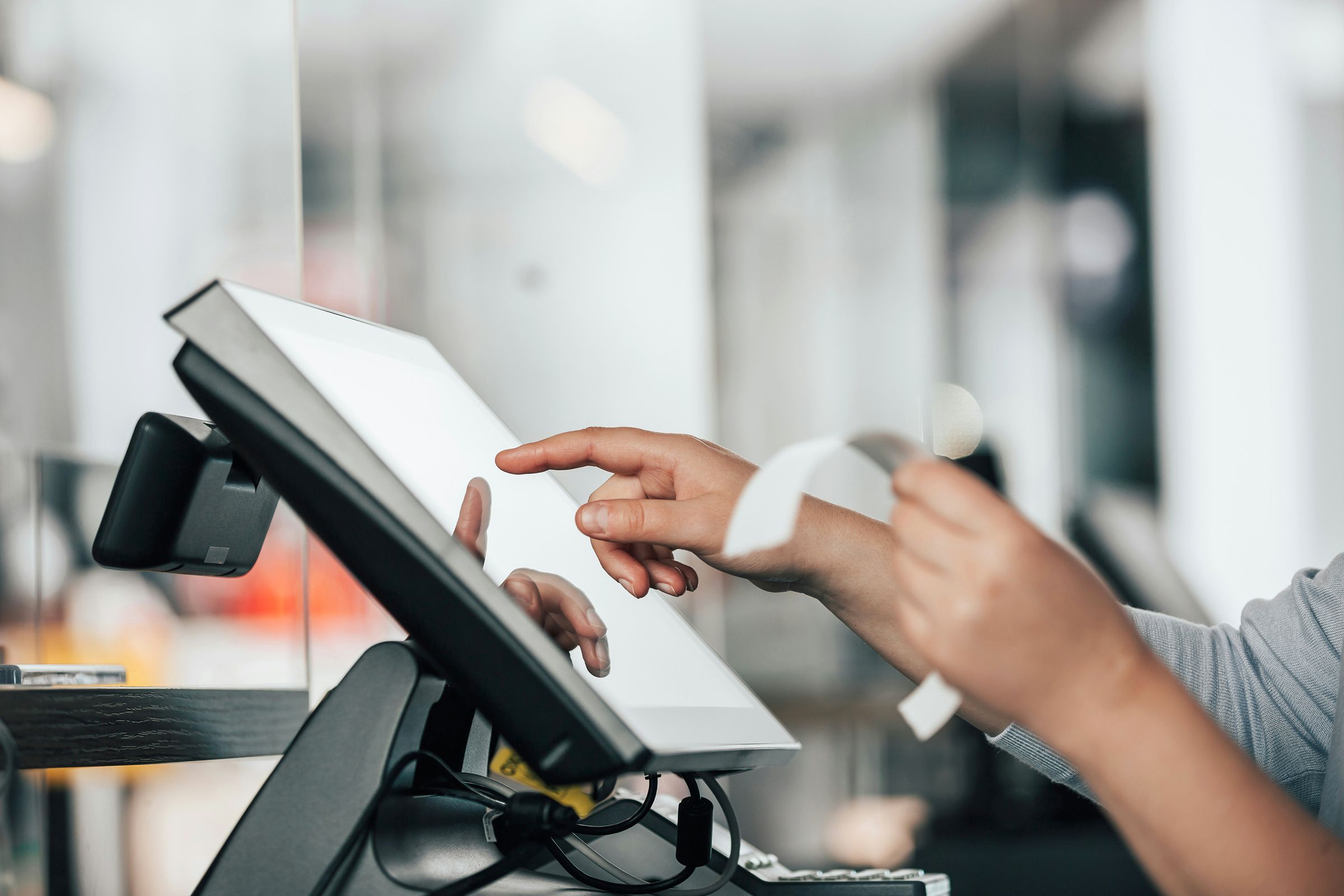Hand touching a POS screen.